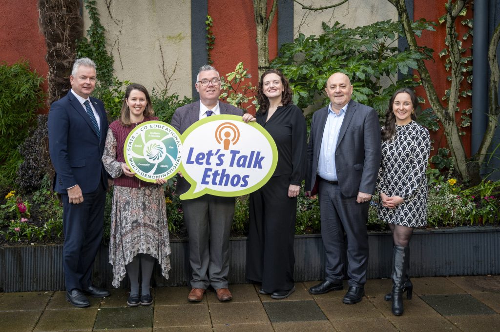 Group of ETBI employees posing for a picture with a Lets Talk Ethos cut out prop