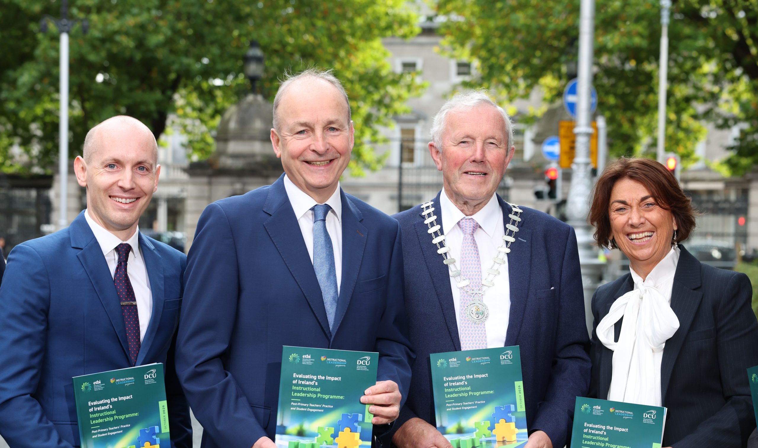Group of men standing with promotional booklet